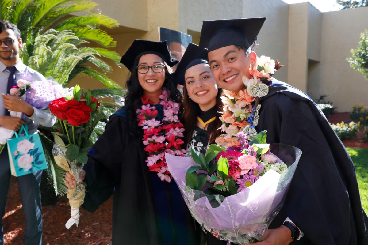 A group of graduates posing for a photo outdoors