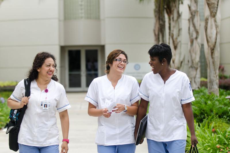 A group of female nursing students in uniform walking outside