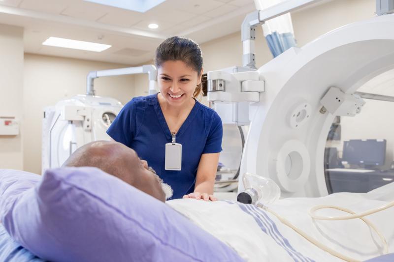 An imaging tech assuring a patient before a scan