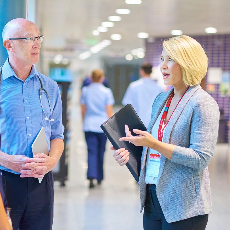 A hospital administrator converses with a doctor and nurse
