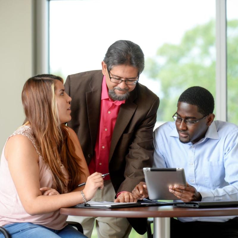 MHA Student with Instructor Around Desk