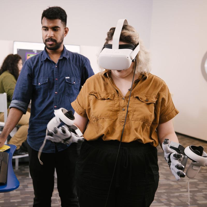 Students using a virtual reality headset and hand-held controls